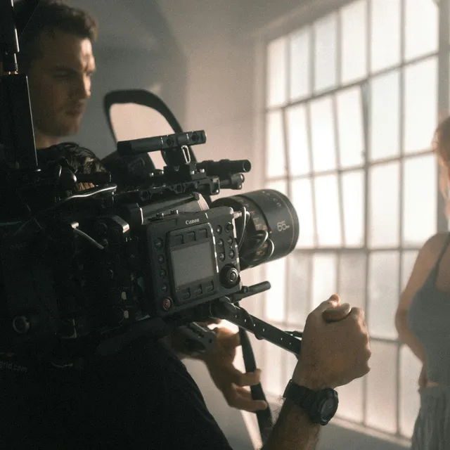 A camera operator filming on set